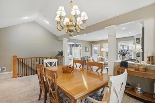 From the dining room, you can see the open flow into the living room and the beautifully crafted iron railing along the open staircaseâadding a custom touch and visual connection to the lower level.