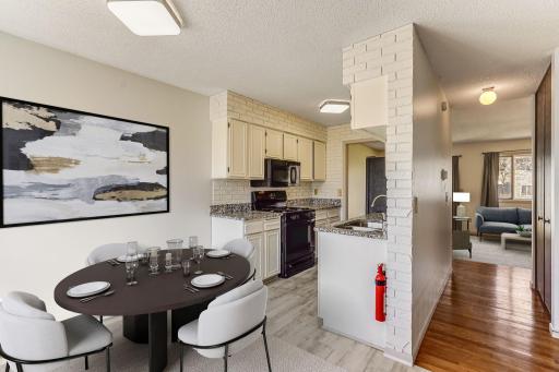 (Virtually Staged) Welcome to 12186 Drake Street NW! This spacious dining room has brand-new flooring that flows seamlessly into the kitchen.