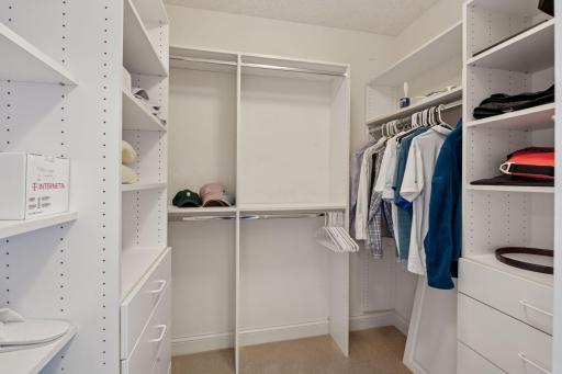 Primary bedroom walk-in closet with organizational compartments