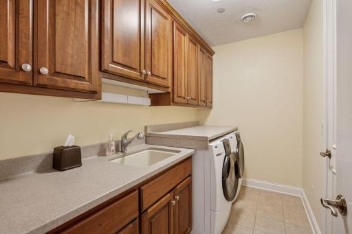 Enjoy the convenience of a dedicated laundry room equipped with a washer, dryer, and plenty of cabinet space