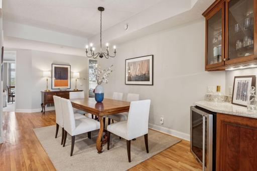 The dining area is equipped with a sleek wine cooler and built-ins, perfect for showcasing your favorite barware or mixing a quick beverage for any occasion.