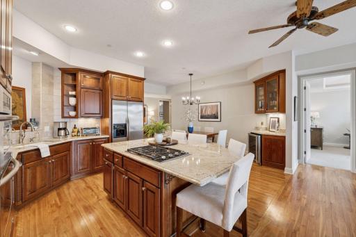 The adjacent eat-in kitchen is a chef's delight, complete with granite countertops, a kitchen island, and sleek stainless steel appliances.