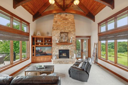 The inviting gas fireplace features floor-to-ceiling stacked stone and offers an adjacent entertainment center.