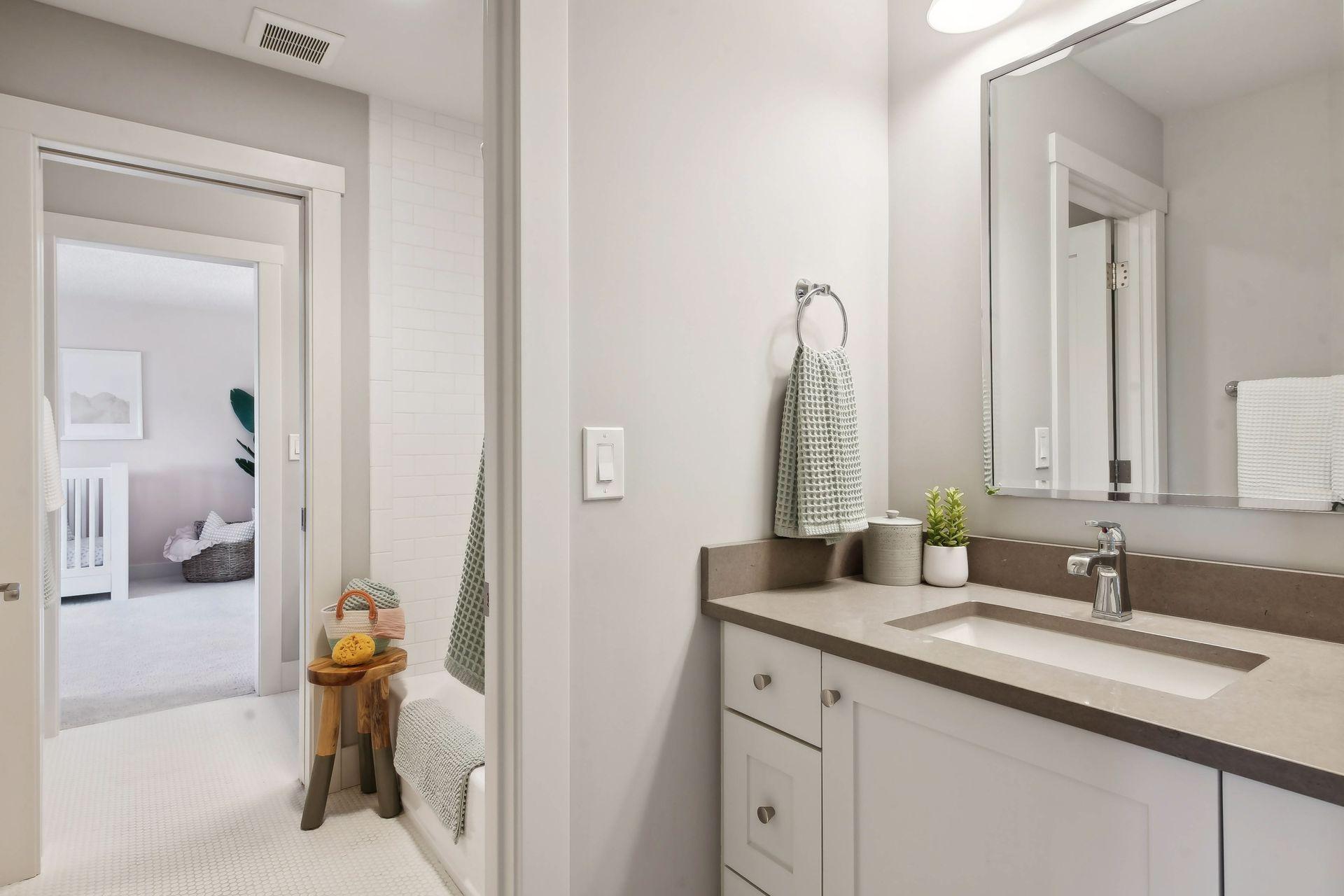 Jack and Jill bathroom with pocket doors separating the toilet room, bath & each vanity.
