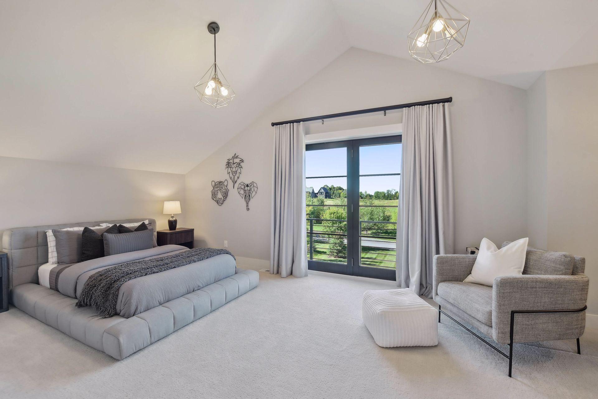 This second bedroom features a small Juliet balcony, vaulted ceilings and a walk-in closet.