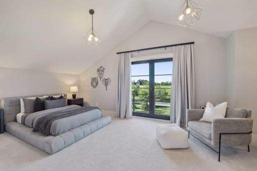 This second bedroom features a small Juliet balcony, vaulted ceilings and a walk-in closet.