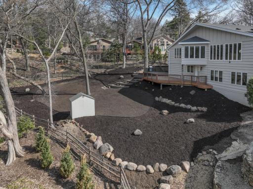 Backyard photo with new mulch, boulders, edging and area for new sod
