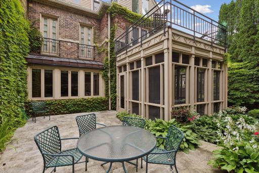 An incredible secluded back patio with a screened porch and upper balcony off the primary suite maximizing outdoor living.