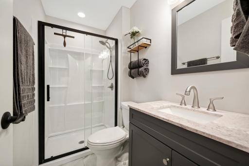 Updated primary bathroom with new shower, vanity, and luxury vinyl tile flooring.