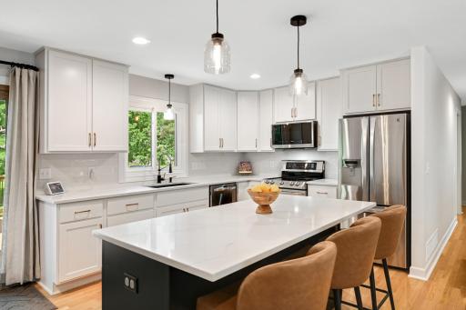 Wall removed to create this outstanding kitchen. Custom cabinets and center island. Quartz countertops, tile backsplash, top-of-the-line stainless steel appliances. Every detail is perfection.