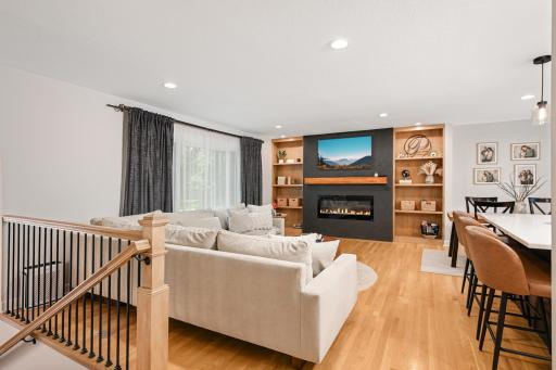 Remodeled electric fireplace finished with roman clay and flanked with wooden built-in shelves.