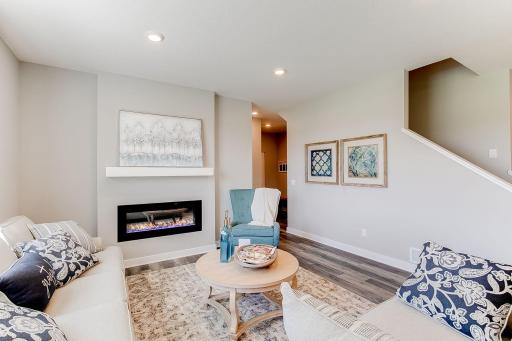 The home's family room is nicely sized & the fireplace provides warmth & ambiance. Photo of model home similar to new Henry plan, color & options will vary.