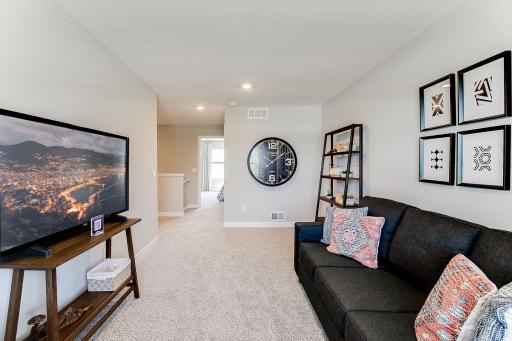 Relax, play and enjoy! This upper level loft room provides an additional gathering space. Photo of model home similar to new Henry plan, color & options will vary.