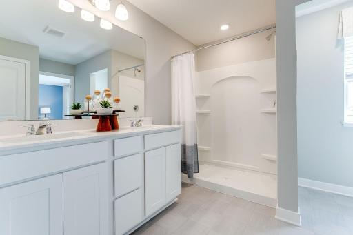 An extension of the primary suite, this private & spacious bathroom contains a double-vanity, a stand-in shower & access to a large walk-in closet!! Photo of model home similar to new Henry plan, color & options will vary.