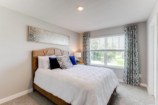 This bedroom, one of four upstairs features a walk-in closet. Photo of model home similar to new Henry plan, color & options will vary.