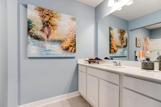 Those bedrooms each have easy access to this deep and spacious bathroom! Photo of model home similar to new Henry plan, color & options will vary.