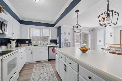 Spacious kitchen with ample counter space, modern lighting, and direct sightlines to the dining area. End-unit placement adds brightness and an open feel.