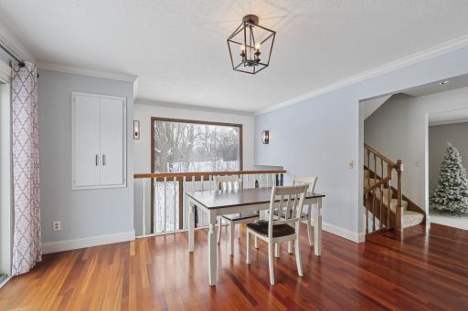 Sun-filled dining space overlooking the outdoors, featuring hardwood flooring and open sightlines. Extra windows from the end-unit layout create an airy, welcoming atmosphere.