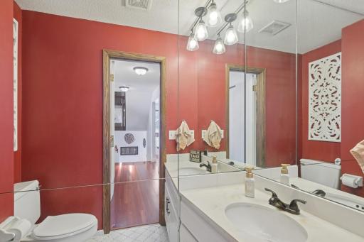 Main-level bathroom with large vanity mirror, updated lighting, and bold accent walls. Bright and functional, benefiting from the home’s end-unit design.