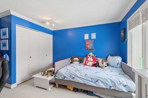 Well-sized second bedroom with ample storage and flexible layout options. Large windows and end-unit placement offer an open, airy atmosphere.
