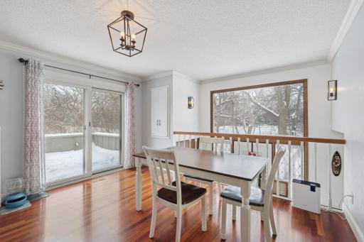 Bright dining area with hardwood floors and sliding glass doors leading to a private deck. As an end unit, this space benefits from abundant natural light and scenic views.