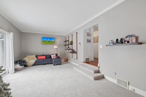 Open sightlines from the living room to adjacent spaces highlight the home’s functional layout. End-unit windows enhance the brightness throughout this level.