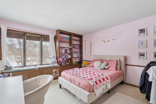 Bright space used as third bedroom featuring soft neutral tones, plush carpet, and large windows. The end-unit layout allows natural light to fill the room, creating a cheerful and comfortable space.