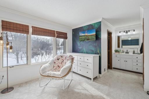 Sun-filled corner of the primary bedroom ideal for reading or relaxing. Large windows and open floor space highlight the home’s light and inviting atmosphere.