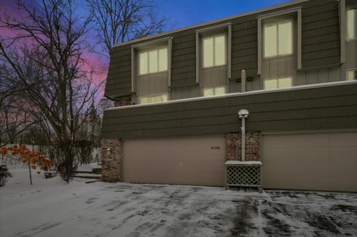 Twilight exterior view emphasizing the home’s charming architecture and end-unit position. Warm interior lighting contrasts beautifully with the evening sky.