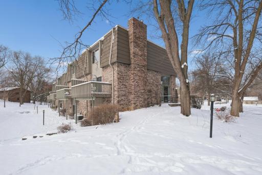 Rear exterior showcasing multiple decks and lower-level patio access. The end-unit placement offers expanded outdoor enjoyment and scenic views.