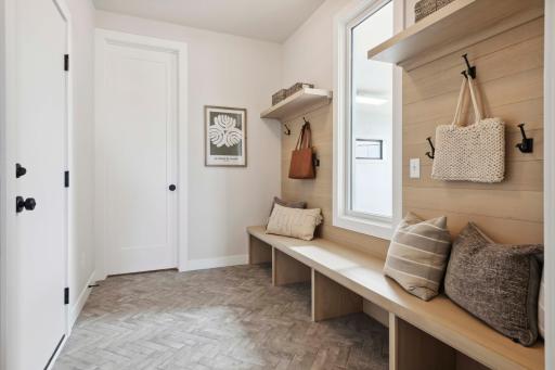 Spacious mudroom with built in bench and large closet. Window overlooks Stunning Sport Court! Photos, virtual/video tours may not depict actual home. Features, materials & finishes shown contain options that are not included in price.