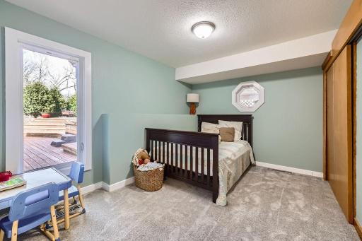 This main floor bedroom features a huge window overlooking the deck outside and a large closet. There is not lack of sunshine in this home with all the unique windows throughout. This is truly a custom home
