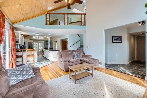 Two Story high vaulted wood-paneled ceiling with a ceiling fan, adding height and character to the space. Truly an open concept home form top to bottom