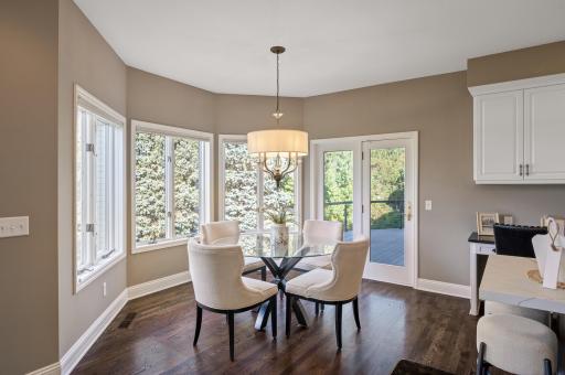 The adjacent informal dining space features backyard views and direct access to the deck, perfect for entertaining or enjoying outdoor meals.