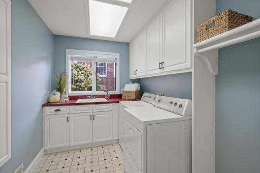 The mudroom provides seamless access to the heated 3-car garage, plus adjacent is the laundry room featuring cabinetry, a washer and dryer, and a utility sink.