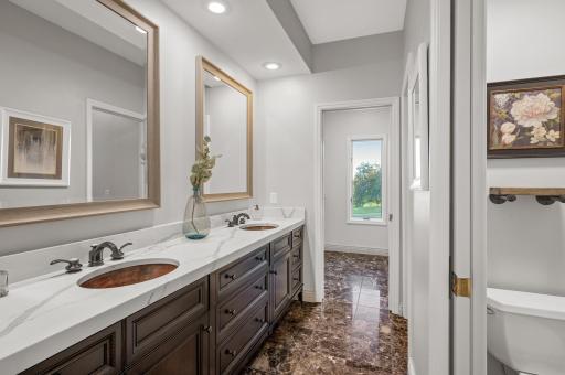 The spa-like bathroom includes dual copper sinks, heated floors, a walk-in shower, a copper soaking tub, and dual walk-in closets.