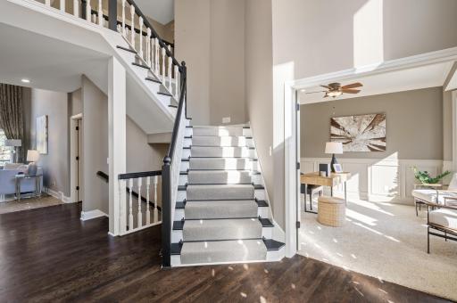 Stunning foyer, boasting soaring 18-foot ceilings, floor-to-ceiling windows that flood the space with natural light, an open staircase, and gleaming hardwood floors that flow throughout much of the main level.