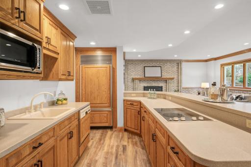 The adjacent second kitchen with a two-tiered peninsula is ideal for hosting gatherings.