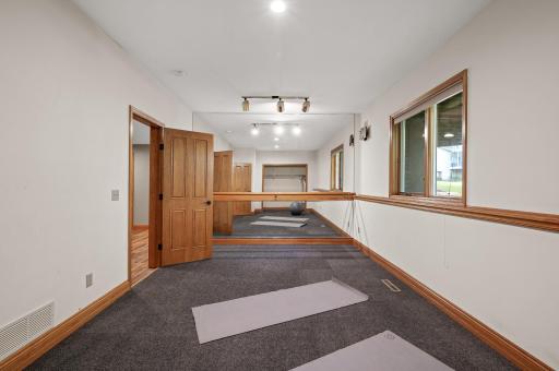 View of the second lower level bedroom, currently set up as a workout room with a floor-to-ceiling mirror.
