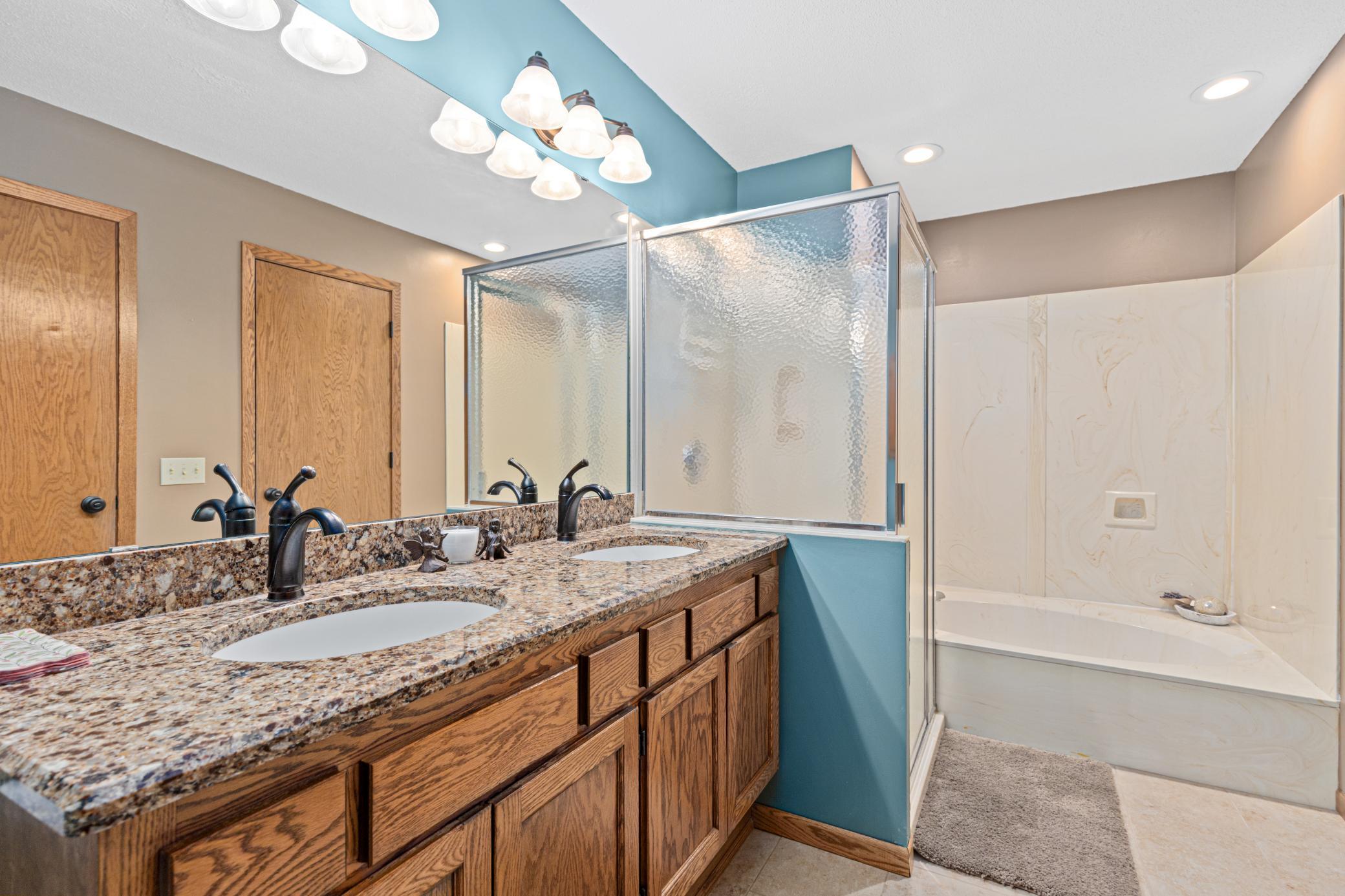 Full upper bath with dual vanity, walk-in shower, and soaking tub