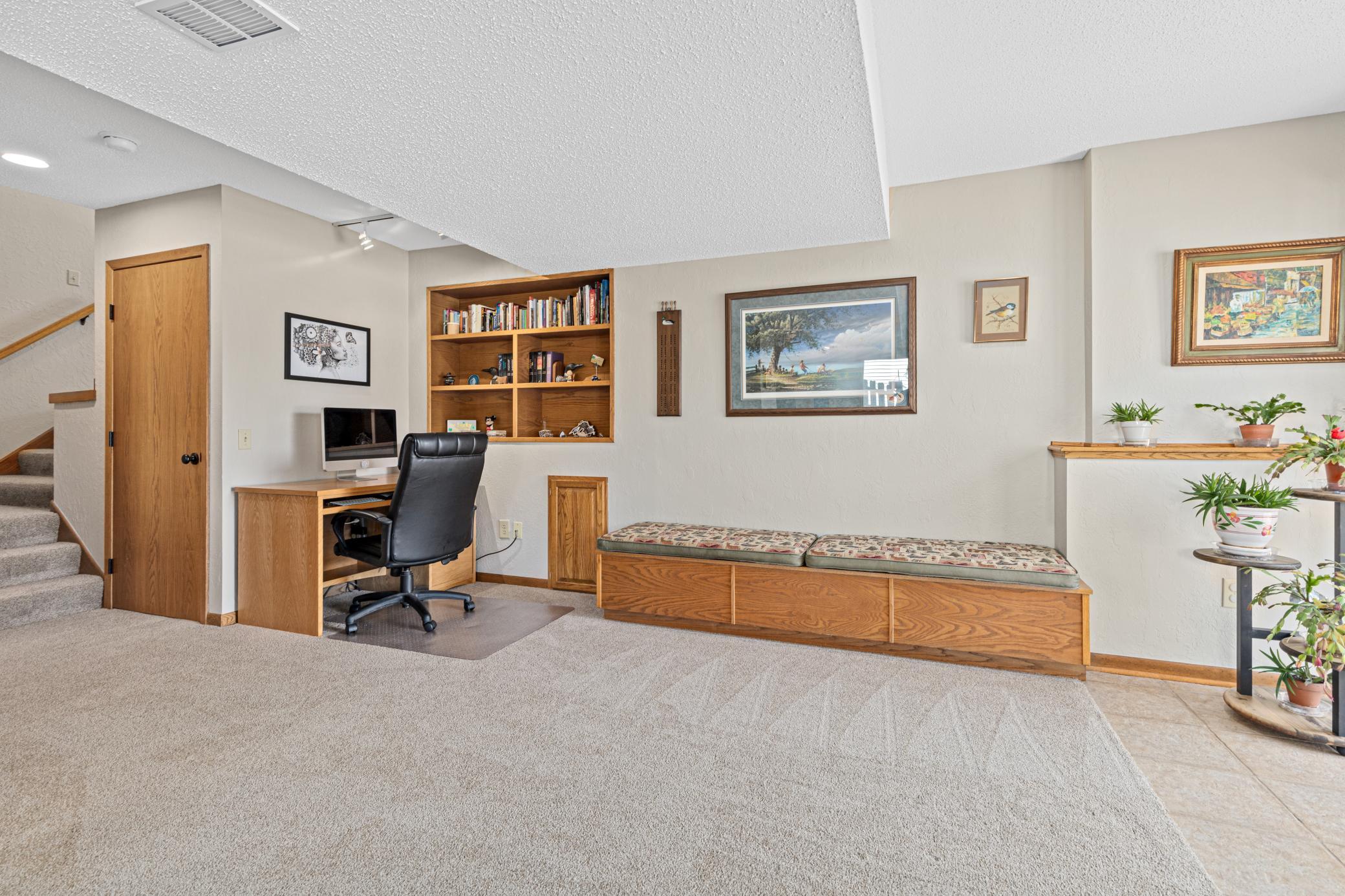 Lower level family room with built-in bench that includes storage