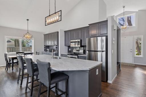 Updated and well-appointed kitchen with large center island, stone counter tops, and SS appliances