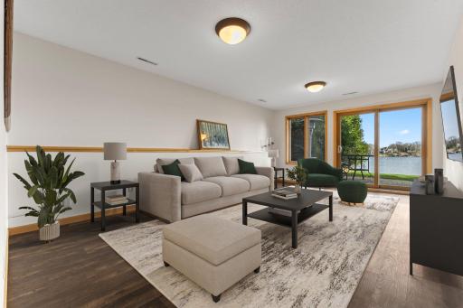The family room on the walk-out level steps out onto a paver patio (virtual staging)
