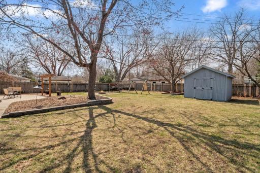 Huge, fully fenced backyardâcomplete with a spacious patio, firepit, and large storage shed