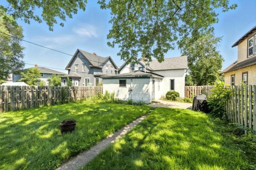 Fenced backyard with patio area for the barbecue grill.