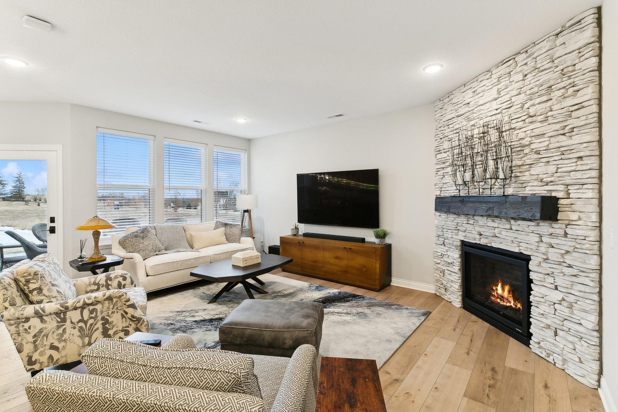 Cozy fireplace in the living room with beautiful stone surround + display mantle.