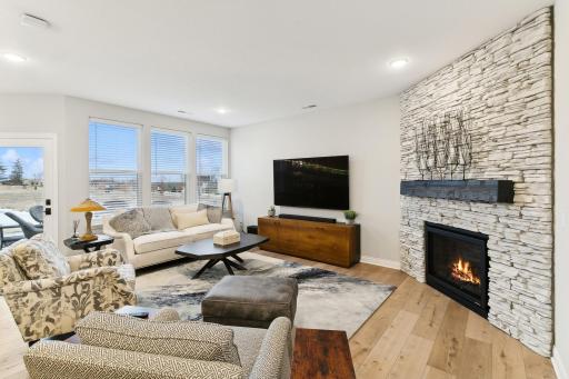 Cozy fireplace in the living room with beautiful stone surround + display mantle.