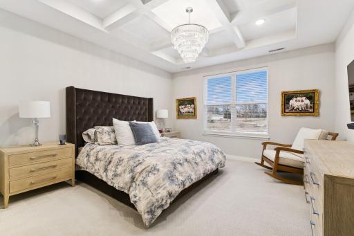 Primary bedroom with lovely natural light and a scenic view. Don't miss the upgraded coffered ceiling with recessed lighting. Note: Chandelier is NOT included in the sale.