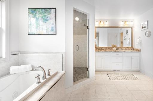 Primary bathroom features dual vanity and separate jetted tub