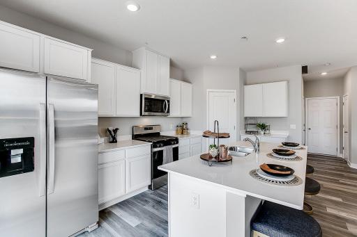 Stainless steel appliances featuring a gas range and microwave that vents to the exterior. *Model home- colors and finishes will vary.
